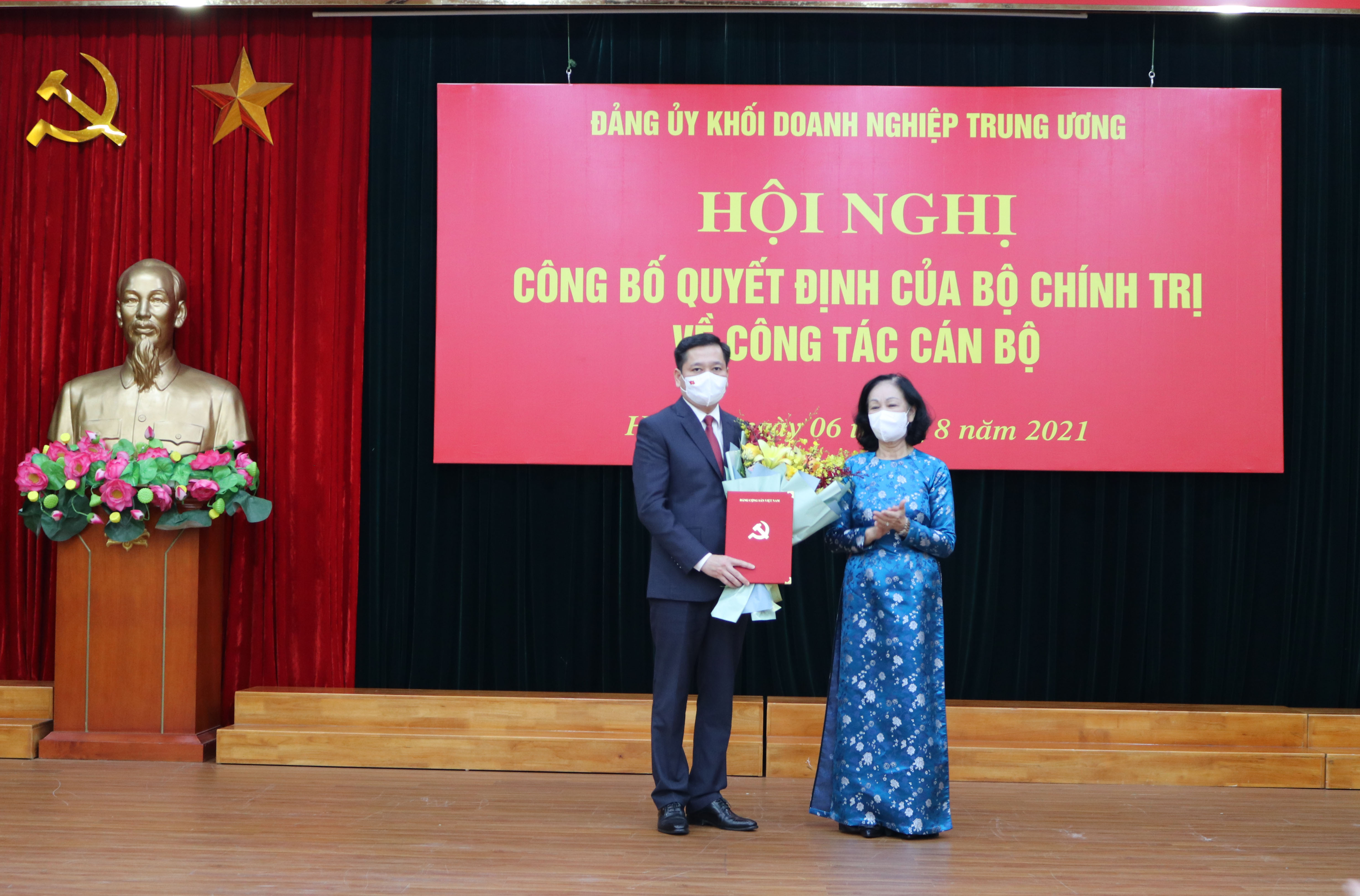 Đồng chí Trương Thị Mai, Ủy viên Bộ Chính trị, Bí thư Trung ương Đảng, Trưởng Ban Tổ chức Trung ương trao quyết định, tặng hoa chúc mừng đồng chí Nguyễn Long Hải.